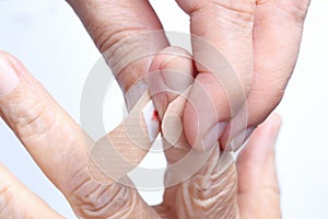 Nurse putting adhesive bandage on elderly hand