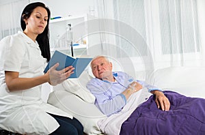 Nurse reading a book to his patient