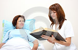 A nurse reading to a patient