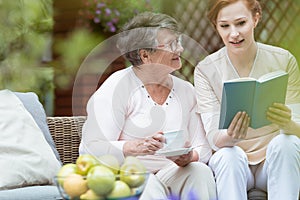 Nurse reading to pensioner