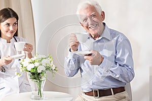 Nurse and retiree drinking coffee