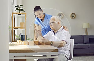 Nurse in retirement home helping demented senior man with brain training activities