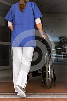 nurse rolls a patient in a wheelchair