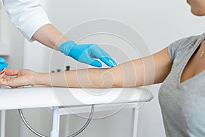 The nurse rubs the hand with alcohol before taking blood from a vein for testing. Disinfects the place of introduction of a needle