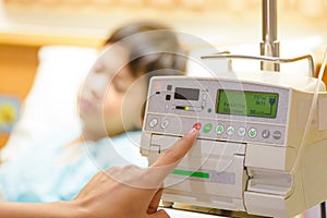 Nurse`s hand pressing on infusion pump intravenous IV drip