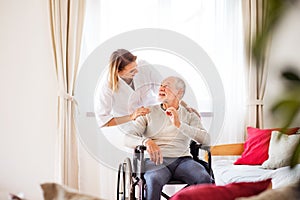 Nurse and senior man in wheelchair during home visit.