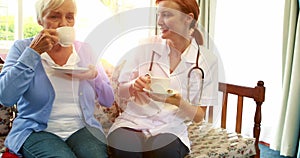 Nurse and senior patient drinking coffee together