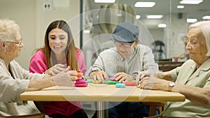 Nurse and seniors having fun playing skill games in geriatrics