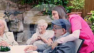 Nurse and seniors talking and laughing in a geriatrics