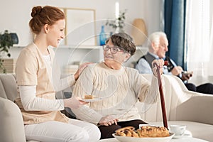 Nurse serving cake for pensioner