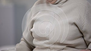 Nurse serving dinner to old patient, elderly woman refusing to eat porridge