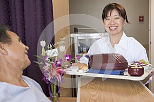 Nurse Serving A Patient A Meal In His Bed