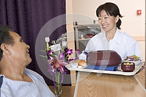 Nurse Serving A Patient A Meal In His Bed