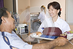 Nurse Serving A Patient A Meal In His Bed