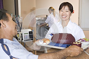 Nurse Serving A Patient A Meal In His Bed