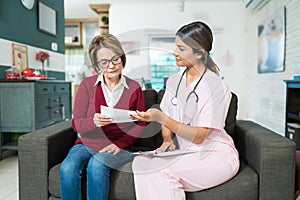 Nurse Showing Reports To Senior Patient At Home photo