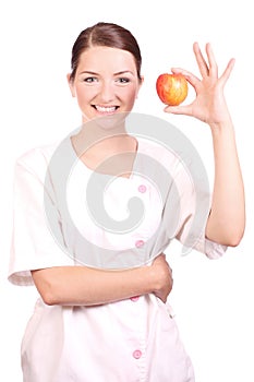 Nurse smiling and holding up an apple