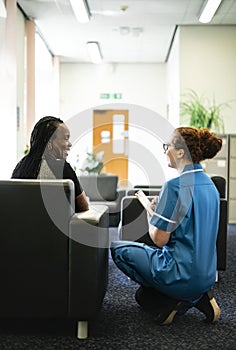 Nurse speaking to a patient in the waiting room photo