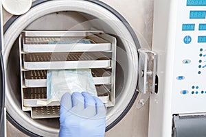 Nurse is sterilizing bandages in autoclave at dental office