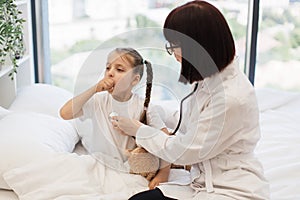 Nurse with stethoscope examining coughing little girl