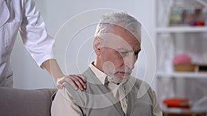 Nurse supporting depressed pensioner in rehabilitation center, benevolence