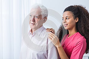 Nurse supporting elder man