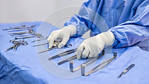 Nurse or surgeon pick up medical equipment on surgical table inside operating room in hospital.People use tool for surgery