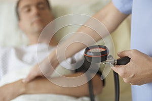 Nurse Taking Blood Pressure And Pulse Of Patient photo