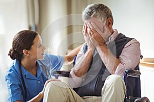 Nurse taking care of sad senior man