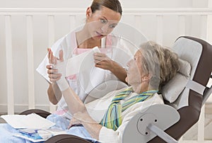 Nurse taking care of senior woman in retirement home