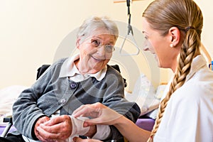 Nurse taking care of senior woman in retirement home photo