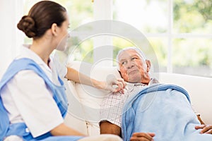 Nurse taking care of sick elderly patient