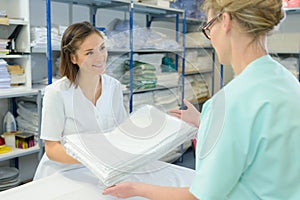 Nurse taking clean sheets from hospital laundry