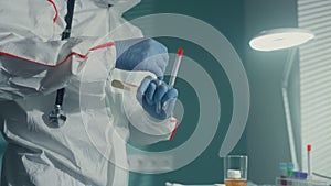 Nurse taking mouth swab in protective suit gloves infectious department closeup.