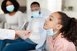 Nurse taking nasal PCR test sample from black teen girl