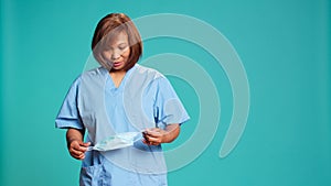 Nurse taking off protective face mask