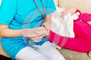 Nurse taking the pulse of her patient at home