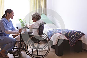 Nurse talking with senior female patient at nursing home