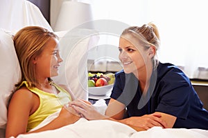 Nurse Talking To Child Patient In Hospital Bed