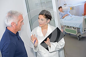 Nurse talking to family member outside patient`s room