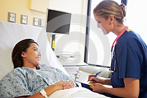 Nurse Talking To Female Patient On Ward