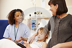 Nurse Talking To Mother And Daughter In Hospital Bed