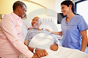 Nurse Talking To Senior Couple In Hospital Room