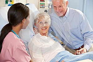 Nurse Talking To Senior Couple On Ward photo