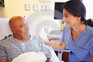 Nurse Talking To Senior Male Patient In Hospital Room