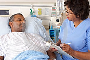 Nurse Talking To Senior Male Patient On Ward photo