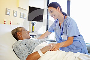 Nurse Talking To Senior Woman In Hospital Room