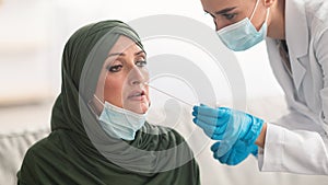 Nurse Testing Muslim Patient For Coronavirus Making PCR Test Indoor