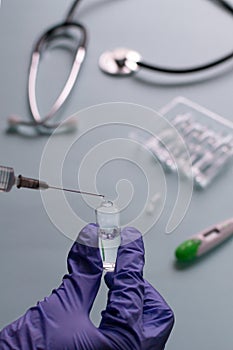 A nurse is typing a vaccine into a syringe on a blue background. Vaccination. COVID-19, SARS - CoV2 Vaccine concept. photo