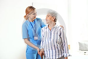 Nurse in uniform assisting elderly woman